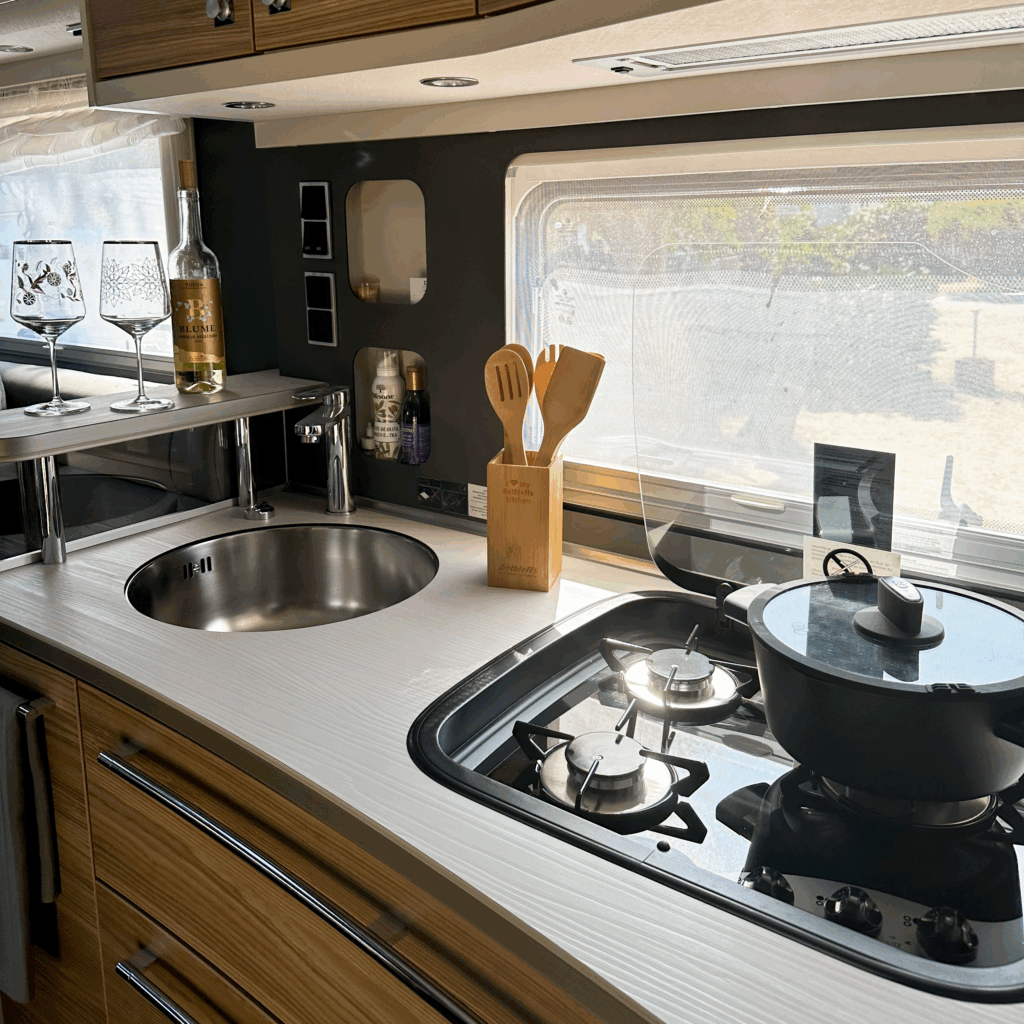 Moderne Küchenzeile im Dethleffs Alpa Wohnmobil mit Gasherd, Spüle, Kochutensilien.